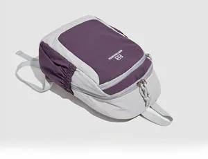 Macro side view showing the dual-compartment structure and purple nylon fabric of the backpack