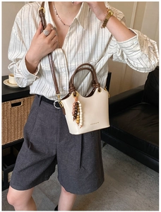 Sac seau blanc cassé avec poignées marron et breloque bohème en perles colorées