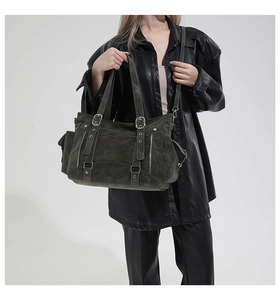 Detail of dark olive green tote bag showing vintage leather texture and zipper accents