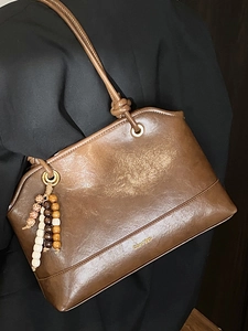 Retro brown leather tote bag with unique wood bead tassel and gold lettering detail