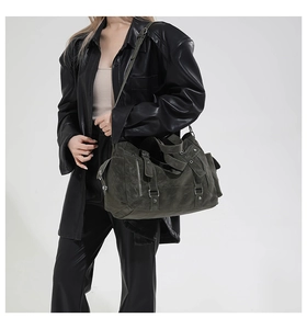 Detail of vintage olive green oversized tote bag with decorative straps and metallic studs