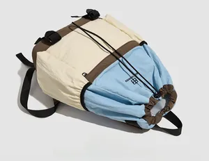 Flat lay of color-blocked drawstring backpack with buckle closure and brand logo detail