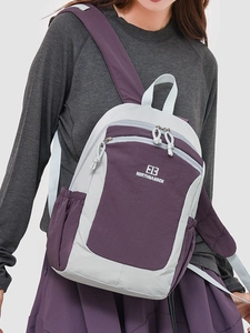Minimalist purple and grey outdoor backpack with adjustable straps on a person