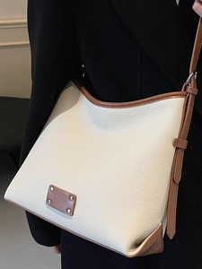 Minimalist beige contrast tote bag with brown leather trim and silver rivets in a commute style