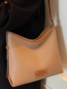 Brown litchi pattern leather tote bag with trapezoid design and shoulder strap