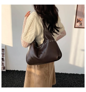 Détails des œillets en métal argenté sur le sac fourre-tout hobo en cuir marron foncé