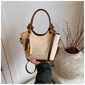 Détail du sac à main rétro blanc crème avec poignée nouée et perles en bois colorées