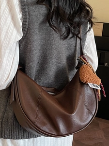 Minimalist coffee brown hobo shoulder bag with contrast stitching and heart charm accessory