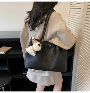 Détail du grand sac cabas noir mat avec bandoulière et breloque chien en peluche