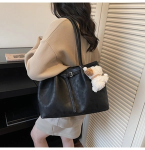 Détail du grand sac cabas noir en similicuir avec un pendentif chien en peluche blanc