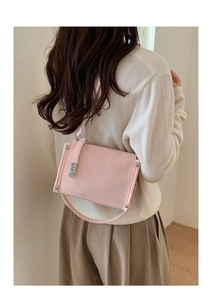 Rear view of a model wearing a pink baguette bag with pleats and silver rivets