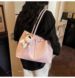 Détail du sac cabas en similicuir rose avec sangle décorative et breloque chiot en peluche