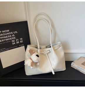 Détail du sac fourre-tout en similicuir blanc crème avec un charmant pendentif chien