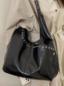 Sac fourre-tout noir brillant avec détails d'œillets argentés pour le trajet quotidien