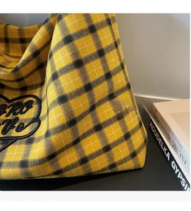 Close-up of checkered fabric tote bag with heart embroidery and soft woven texture