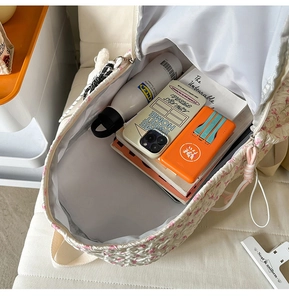 Interior view showing large capacity and pink bow texture of this off-white backpack