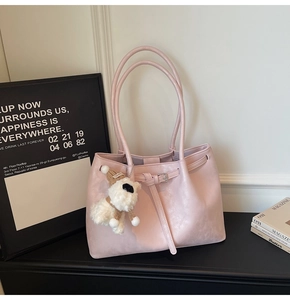 Détail du sac cabas en similicuir rose clair avec un porte-clé chien en peluche doux