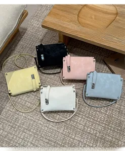 Detail shot of vintage square crossbody bags in five colors on a textured carpet