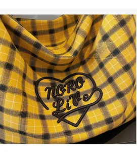 Close-up of yellow checkered canvas tote with heart embroidery and noro live text detail