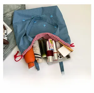Draufsicht der blauen Denim-Tragetasche mit großem Fassungsvermögen und rot kariertem Futter