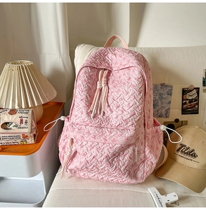 Close-up of pink floral embossed fabric backpack with contrast drawstring details