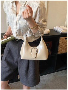 Détail du sac hobo beige crème montrant le similicuir lisse et la grande boucle argentée