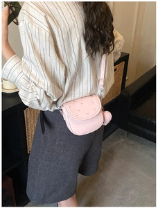 Sacoche rose avec broderie en cœur et pompon en fourrure assorti sur le côté