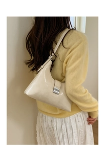 Rear view of cream white crescent tote bag with silver buckle worn by model