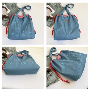 Detailansicht der Denim-Tragetasche mit rot-weißem Karofutter und Herz-Stickerei