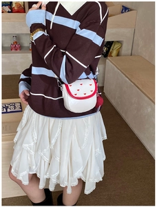 Mini sac bandoulière blanc avec broderie cœurs rouges et pompon porté par un mannequin