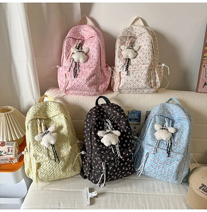 Detailed view of quilted and floral backpacks in pastel colors with cute bear pendants