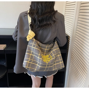 Close-up of yellow heart embroidery on grey plaid tote bag with wide strap