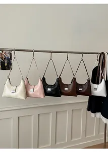 Detail shot showing six retro hobo bags in various colors with metallic silver buckles