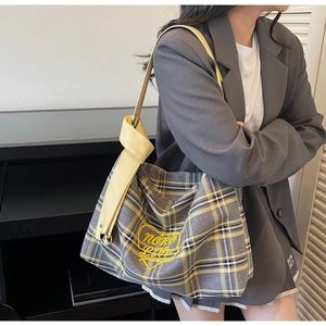 Close-up of yellow plaid tote bag with more love heart embroidery and knotted wide strap
