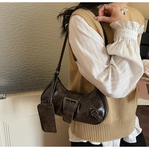 Detail of vintage dark brown crescent bag with metal buckle and small detachable pouch