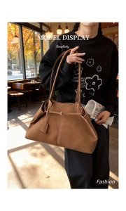 Détail du grand sac cabas caramel au fini mat avec surpiqûres verticales dans un café