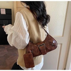 Detail view of brown vintage leather shoulder bag with buckle and mini coin pouch accessory