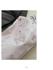 Detail of pink faux leather tote bag showing wood horse embroidery and soft texture