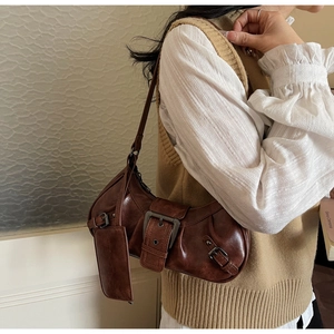 Detail of vintage brown shoulder bag with buckle strap and small hanging card pouch