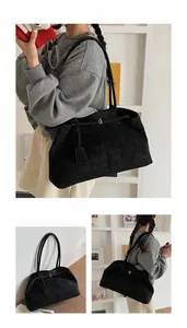 Détail d'un grand sac cabas en daim noir avec boucle dorée et bandoulière large