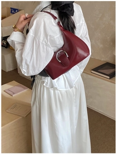 Vue détaillée du sac à bandoulière bordeaux avec boucle fer à cheval argentée