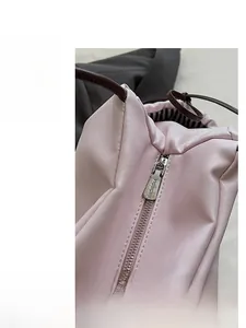 Close-up of smooth silver zipper and star quilting detail on a light pink tote bag