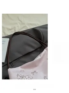 Detail of light pink leather bag featuring dark brown horse embroidery and slim shoulder strap