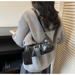 Close-up of vintage black motor-style shoulder bag with large buckle and small pouch
