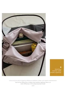 Detail view of large capacity pink tote bag interior showing books, umbrella and phone