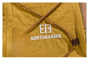 Vue macro d'un sac à dos en nylon jaune avec logo EI3 Northnansen brodé