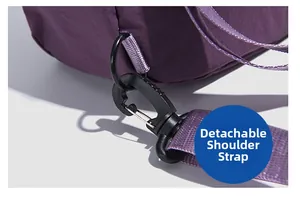 Detail view of the detachable shoulder strap and black plastic buckle on the purple nylon bag