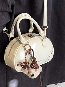 Vintage off-white leather bowling handbag with teddy bear charm and shoulder strap