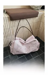 Detail of pink embroidered tote bag with pony patterns and brown shoulder straps