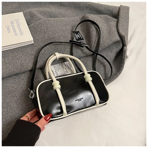 Gros plan du sac Boston noir et blanc avec logo HAIOU & BAGS et texture en cuir synthétique
